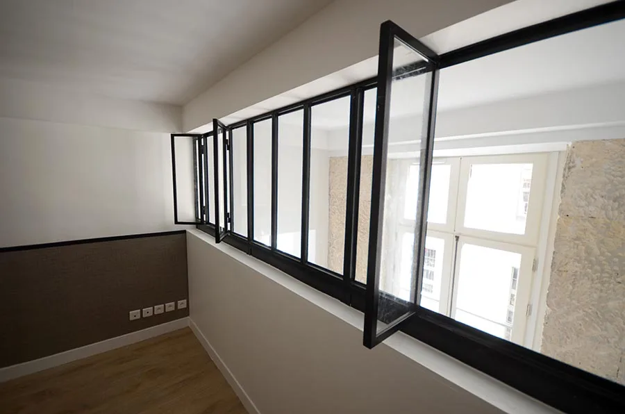 Une des chambres en mezzanine, avec sa large ouverture sur l'espace de vie Aménagement de trois appartement à Paris