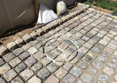 Pavage d'une plaque de regard dans une allée
