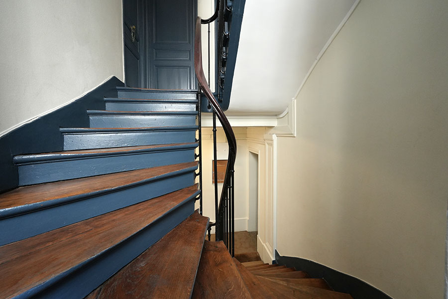 Trois tons, bleu, blanc cassé sur les murs et blanc pur au plafond Rénovation d'une cage d'escalier à Paris