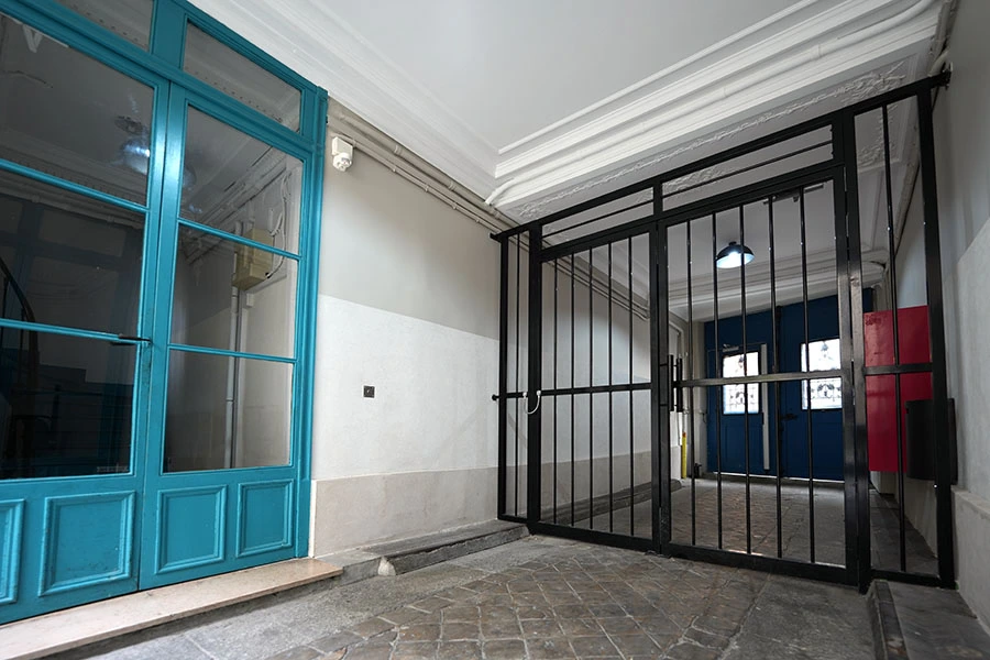 Renovation du porche de cette entrée d'immeuble avec des enduits à la chaux aérienne permettant de faire respirer les murs Travaux porche entrée copropriété à paris