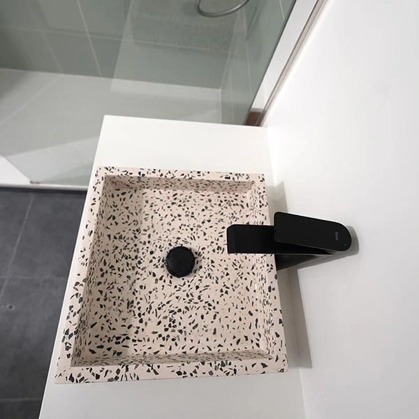 Détail de la vasque terrazzo et de son mitigeur noir Rénovation d'un appartement à Charenton-le-Pont