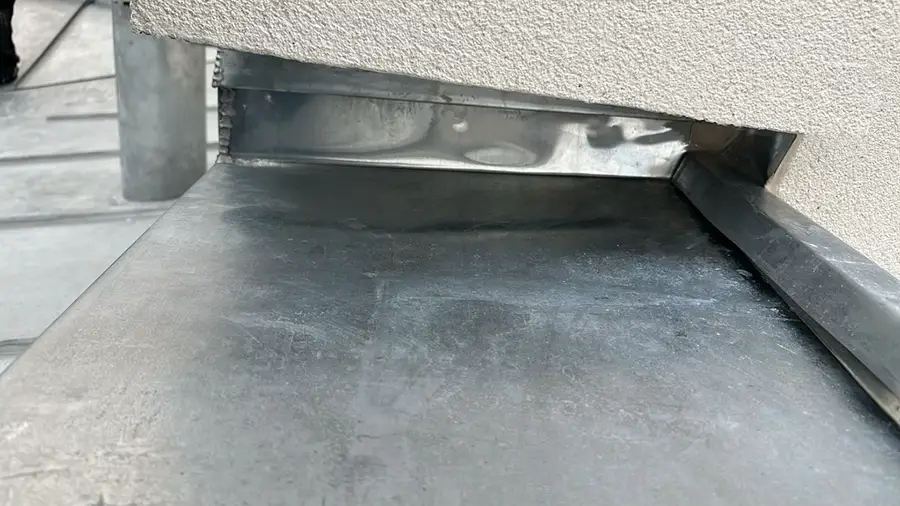 Détail d'un solin sous l'isolation thermique extérieure Détail du solin avec une toiture en zinc